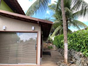 a building with a garage door and a palm tree at Canto das Acácias in Fernando de Noronha