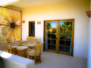 Tripui Hotel في Puerto Escondido: غرفة مع طاولة وكراسي على الفناء