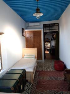 een kamer met een bed en een blauw plafond bij dar said in Rabat