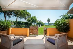 a patio with chairs and a table and a fence at Ammos Sea Front Rooms - Adults only in Vasilikos