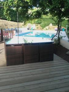a hot tub sitting on a deck next to a pool at Logis Hôtel Restaurant L'Escapade in Le Crestet
