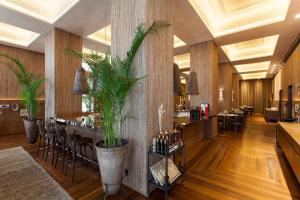 un restaurante con un bar con plantas en la pared en Hotel Fasano Salvador, en Salvador