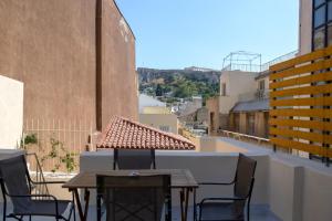 a balcony with tables and chairs on a building at Metis Athens Suites in Athens