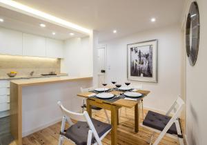 a kitchen and dining room with a wooden table and chairs at Lisbon For You Apartment in Lisbon