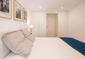 a white bedroom with a bed with a pillow at Lisbon For You Apartment in Lisbon