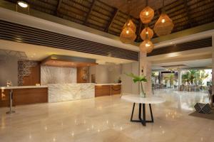 a lobby of a hotel with a table and a bar at Casa Marina Beach & Reef All Inclusive in Sosúa
