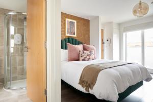 - une chambre avec un lit et une douche en verre dans l'établissement Sonder St Johns Garden, à Londres