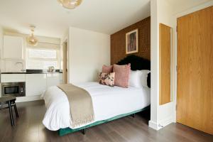 a bedroom with a bed with white sheets and pink pillows at Sonder St Johns Garden in London