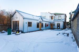 un groupe de maisons dans une cour recouverte de neige dans l'établissement Hostal Boutique Patagonia Mística, à Punta Arenas