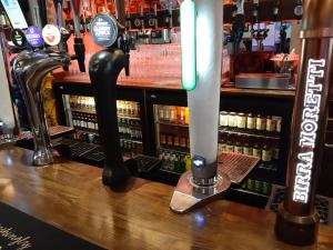 um bar com uma fila de garrafas de cerveja em Hanover Hotel & McCartney's Bar em Liverpool