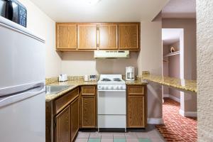 a kitchen with wooden cabinets and a stove at Sundial Inn in Virginia Beach