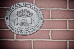 a plaque on the side of a brick wall at Strasburg Village Inn in Strasburg