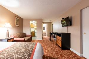 a hotel room with a bed and a flat screen tv at Sundial Inn in Virginia Beach