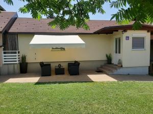 a house with a patio with a white umbrella at Apartment King in Seliste Dreznicko