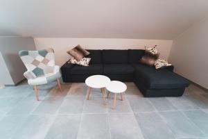 a living room with a black couch and a white table at Open Source à l'entrée du Circuit! in Stavelot