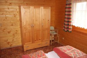 a bedroom with a wooden cabinet in a cabin at Apartmány a Chalupa Tara in Albrechtice v Jizerských horách