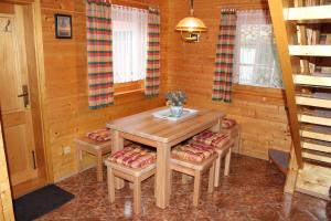 a dining room with a wooden table and two stools at Apartmány a Chalupa Tara in Albrechtice v Jizerských horách