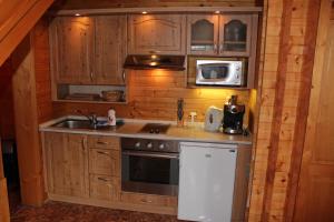 a kitchen with a sink and a stove and a microwave at Apartmány - Chalupa Tara in Albrechtice v Jizerských horách