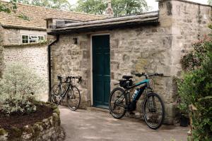 two bikes parked outside of a building with a green door at The Rectory Rooms, Studio 4 in Skipton