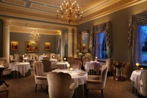 a dining room with tables and chairs and a chandelier at Grantley Hall in Ripon
