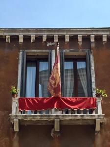 ein Fenster mit einer Flagge darüber in der Unterkunft Alloggi Santa Sofia in Venedig