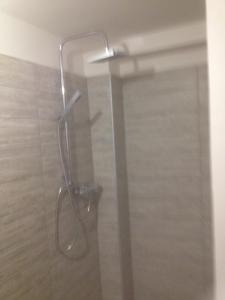 een douche met een glazen deur in de badkamer bij Apartman Luca in Nyíregyháza
