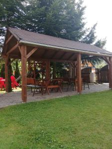 a wooden pavilion with picnic tables in a park at Apartmany Agatha in Loučná nad Desnou