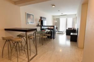 a kitchen and living room with a table and stools at Icaro Suites in Buenos Aires