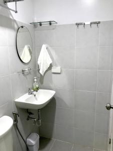 a white bathroom with a sink and a mirror at Cozy and Full Service Condo at the Heart of Bacolod in Bacolod +14 photos