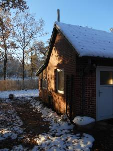 ein Backsteingebäude mit einer weißen Tür im Schnee in der Unterkunft Ferienwohnung Villa Lütt in Bleckede
