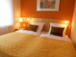 a bedroom with a large bed with orange walls at Ferienwohnungen Villa Lütt in Bleckede