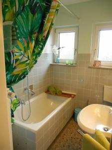 ein Badezimmer mit einer Badewanne und einem Waschbecken in der Unterkunft Ferienwohnung Villa Lütt in Bleckede