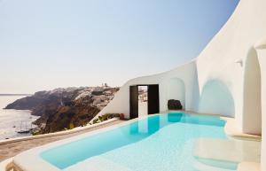 a swimming pool with a view of the ocean at Perivolas Hotel in Oia