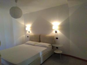 a bedroom with a bed and two lights on the wall at Villa Bungaville a Olbia in Olbia