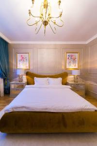 コンスタンツァにあるSeaside Luxury Apartamentのベッドルーム1室(大型ベッド1台、シャンデリア付)