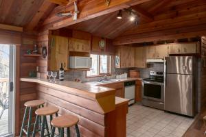 cocina con armarios de madera y nevera de acero inoxidable en Creekside Cabin en Fairmont Hot Springs