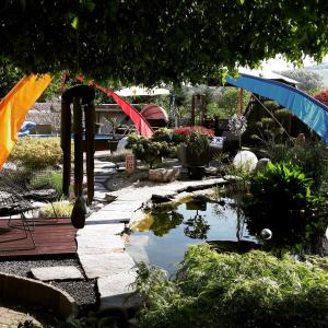 a garden with a pond and umbrellas in a yard at Haus Steffi in Müllheim