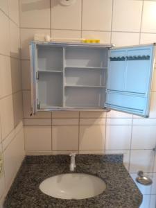 a bathroom with a sink and an open refrigerator at Cond. Golden Thermas Residence - Shapphire Tower in Caldas Novas