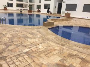 a swimming pool with blue water in a building at B-LBAIT Agadir Morning light for Family in Agadir