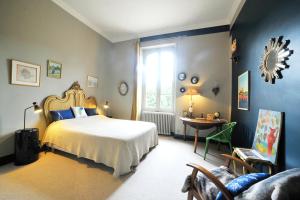 a bedroom with a bed and a table and a window at Clos Saint-Blaise in Albi