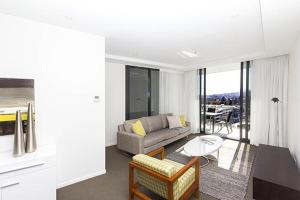 sala de estar con sofá y mesa en AAC Apartments - Manhattan en Canberra