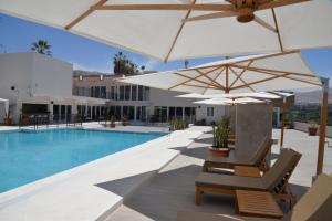 a resort with a pool and umbrellas and chairs at DM Hoteles Moquegua in Moquegua