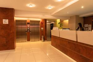 a woman standing at a counter in a hospital lobby at Icaro Suites in Buenos Aires