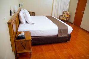 a bed in a room with a wooden floor at DM Hoteles Mossone - Ica in Ica