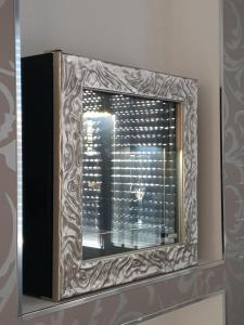a mirror on a wall with a window at Sea Elegance in Oliveri