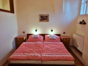 1 dormitorio con 2 camas y mantas rojas y blancas en Apartmány na Trojmezí, byt Florián, en Slavonice