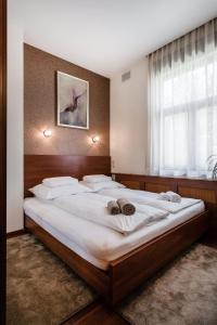 ブダペストにあるCityPark Design Flatの大きな窓付きのベッドルームの大型ベッド1台