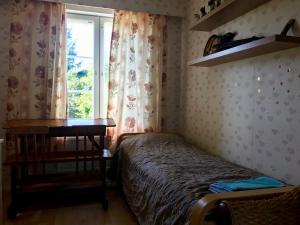 1 dormitorio con cama, escritorio y ventana en Mäkisen Majatalo en Palus