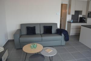 a living room with a couch and two tables at Residentie Capri in Middelkerke