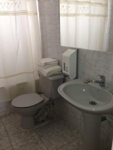 a white toilet sitting next to a sink in a bathroom at Hotel Blanco Encalada in Bahia Inglesa